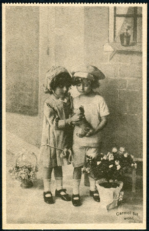 GERMANY - CIRCA 1914: A promotional postcard (Carmol tut wohl) printed in Germany, shows a boy and a girl looking toy, circa 1914のeditorial素材
