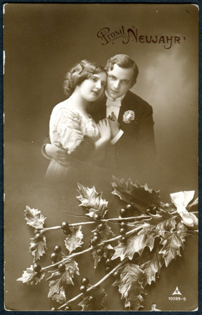 GERMANY - CIRCA 1915: A postcard printed in Germany, shows a couple in love. The inscription in German: Happy New Year, circa 1915のeditorial素材