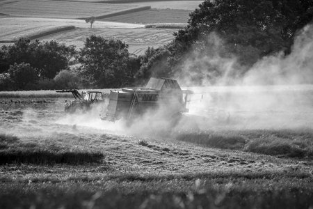 NEUSTADT, GERMANY - JULY 30, 2017: Harvesting on the fields in the suburbs of the small town of Neustadt (Marburg-Biedenkopf district in Hessen). Harvester on the field. Black and white.のeditorial素材