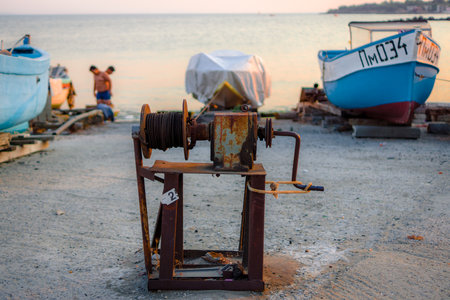POMORIE, BULGARIA - AUGUST 18, 2017: Boats on the beach. Focus on the winch for loading and unloading motor boats.のeditorial素材