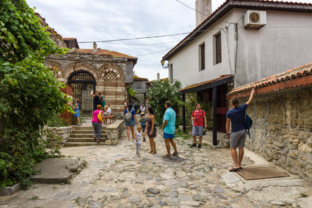NESEBAR, BULGARIA - AUGUST 21, 2017: A street with tourists in the old town and in the background of the Church of the Holy Archangels Michael and Gabriel (built between the 13th and 14th centuries).のeditorial素材