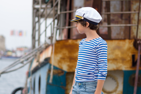 Portrait of a boy in a striped long sleeve T-Shirt (Telnyashka) and captain's cap.の写真素材