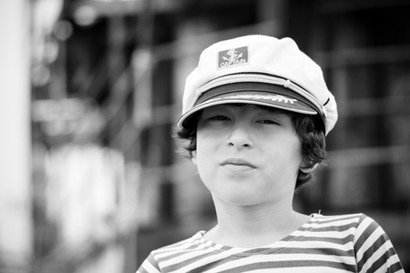 Portrait of a boy in a striped long sleeve T-Shirt (Telnyashka) and captain's cap. Black and white.の写真素材