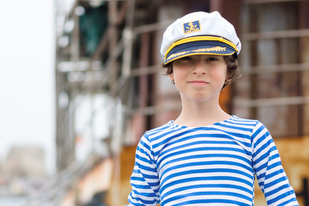 Portrait of a boy in a striped long sleeve T-Shirt (Telnyashka) and captain's cap.