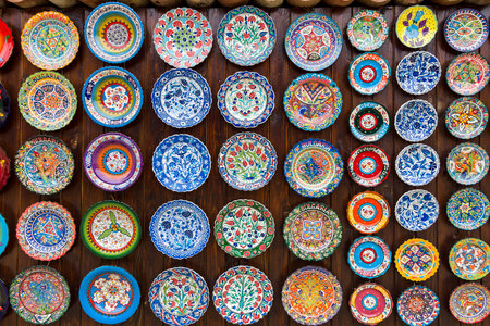 NESEBAR, BULGARIA - AUGUST 21, 2017: Background of plates with traditional national patterns. Showcase of a private shop selling souvenirs and gifts.のeditorial素材