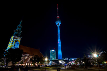 BERLIN - OCTOBER 08, 2017: The Berlin TV Tower (Berliner Fernsehturm) in festival illumination. In the foreground Neptune Fountain and St. Mary's Church (Marienkirche). Festival of lights 2017.のeditorial素材