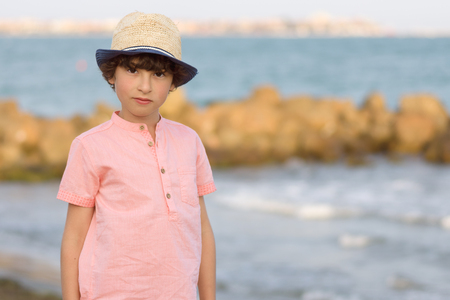 The boy is standing by the sea.の写真素材