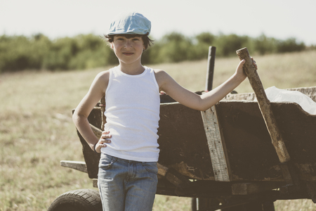 Portrait of a guy in a T-shirt and cap in a rural setting. Vintage toning.の写真素材