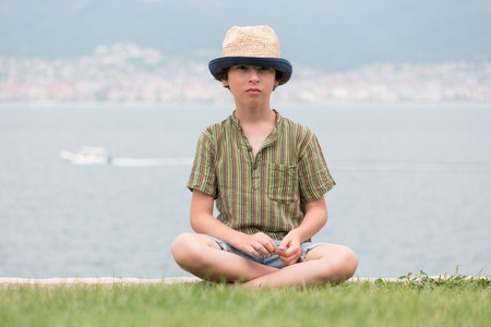 Portrait of a boy in a relaxed pose against the sea.の写真素材