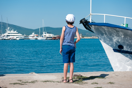 The boy is standing on the pier in the seaport.の写真素材