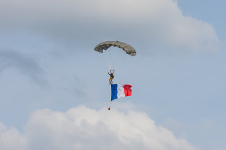 BERLIN, GERMANY - APRIL 27, 2018: Military paratrooper with the flag of France in the sky. Exhibition ILA Berlin Air Show 2018.のeditorial素材