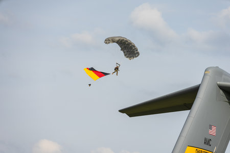 BERLIN, GERMANY - APRIL 27, 2018: Military paratrooper with the flag of Germany in the sky. Exhibition ILA Berlin Air Show 2018.のeditorial素材