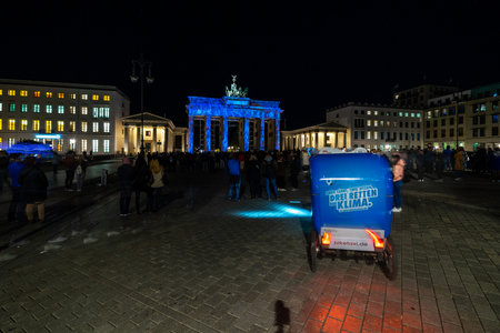 BERLIN - OCTOBER 07, 2018: Pariser Platz and Brandenburg Gate in brightly colored illuminations. Festival of lights 2018.のeditorial素材