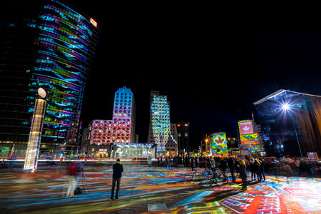 BERLIN - OCTOBER 07, 2018: Modern skyscraper at Potsdamer Platz in brightly colored illuminations. Festival of lights 2018.のeditorial素材