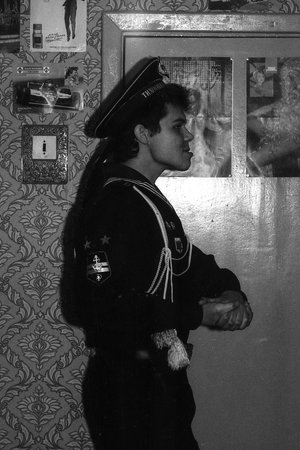 MOSCOW REGION, RUSSIA - CIRCA 1992: Portrait of a russian sailor in an apartment in an unusual pose. Film scan. Large grain, circa 1992のeditorial素材