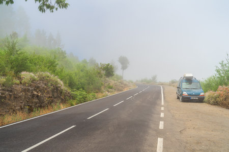 TENERIFE, CANARY ISLANDS, SPAIN - JULY 27, 2018: A car on a foggy mountain road after an accident.のeditorial素材