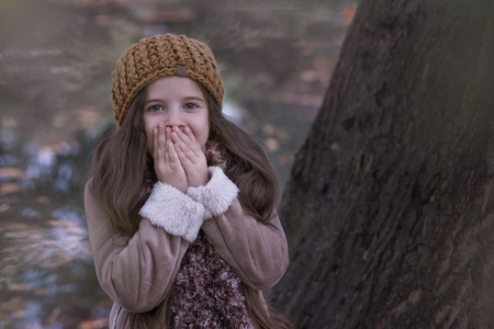 Portrait of a surprised girl in autumn clothes on a background of nature.の写真素材