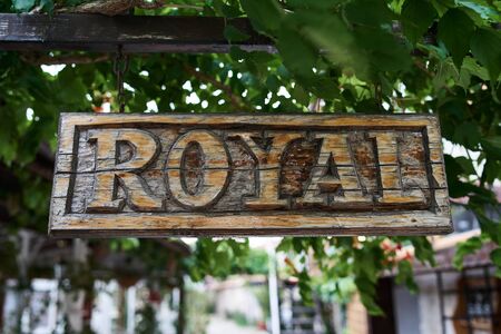 Wood carving. Old wooden signboard with the words "Royal"の写真素材