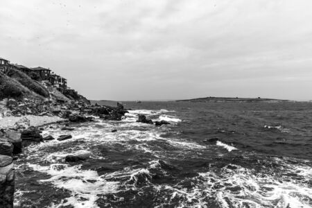 The rocky coast of the Black Sea near the ancient city of Sozopol. Bulgaria. In the In the background are the islands of St. Peter and St. Ivan. Black and white.の写真素材