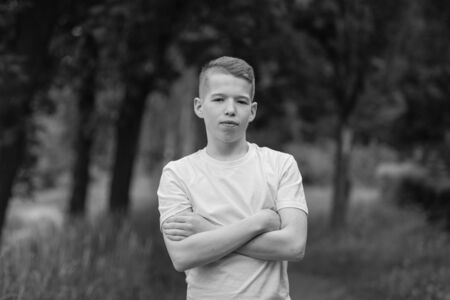 Portrait of a boy on a background of nature. Black and white.の写真素材