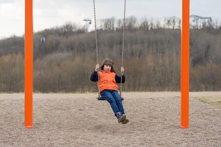 Joyful boy on the playground on a swing.の写真素材