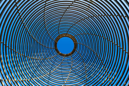 Abstract metal structure in the form of circles against the blue sky.