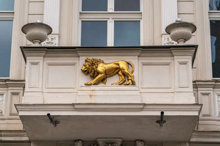 A bas-relief of a golden lion on the balcony of an old building.の写真素材