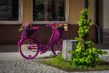 JUETERBOG, GERMANY - MAY 23, 2021: Bicycle decorated with flowers as advertising on the street in the old town. Juterbog is a historic town in north-eastern Germany, in the district of Brandenburg.のeditorial素材