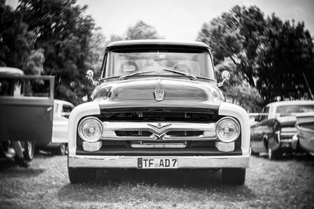 DIEDERSDORF, GERMANY - AUGUST 21, 2021: Full-size pickup truck Ford F-150, 1956, (second generation). Focus on center. Swirly bokeh. Black and white. The exhibition of "US Car Classics".のeditorial素材