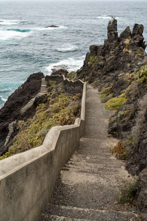 A staircase leading through the rocks, down to the ocean.