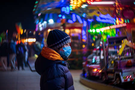 A teenager at a Christmas market during COVID-19 pandemic restrictions.の写真素材