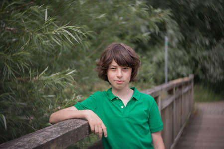 Portrait of a boy standing on a bridge.の写真素材
