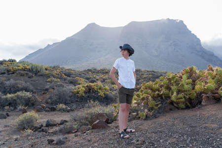 Portrait of a teenager against the backdrop of the Los Gigantes cliffs. View from cape Teno. Tenerife. Canary Islands. Spain.の写真素材