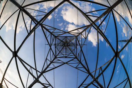 Abstract metal structure (high-voltage power pole) on a blue sky background. Fisheye lens.の写真素材