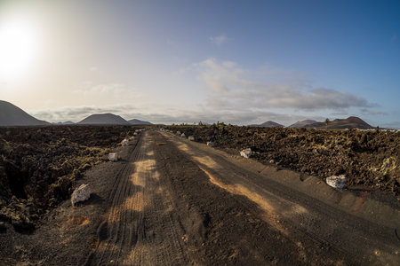 Typical volcanic landscape. Road going into the distance. Lanzarote, Canary Islands. Spain.の写真素材