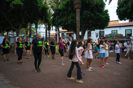 PUERTO DE LA CRUZ, SPAIN - JULY 19, 2023: Group Zumba fitness dance class in the public city park Parque Plaza Del Charco.のeditorial素材