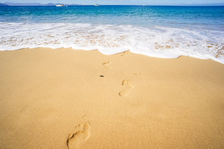 View of the ocean waves, sandy beach and sky.の写真素材