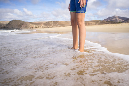 Teenager's feet on the sand, close-up.の写真素材