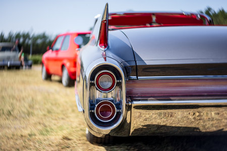 LINTHE, GERMANY - MAY 27, 2023: The stoplights of a full-size luxury car Cadillac Series 62, 1961. Art lens. Swirl bokeh. Die Oldtimer Show 2023.のeditorial素材