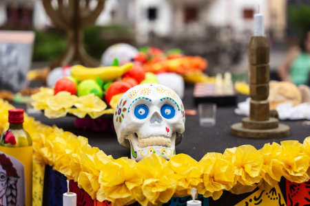 GARACHICO, TENERIFE - AUGUST 5, 2025: Decorative painted skull on altar with yellow paper flowers and colorful festival ornaments during Fiesta de la Muerte, Canary Islands.のeditorial素材