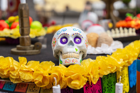GARACHICO, TENERIFE - AUGUST 5, 2025: Decorative painted skull on altar with yellow paper flowers and colorful festival ornaments during Fiesta de la Muerte, Canary Islands.のeditorial素材