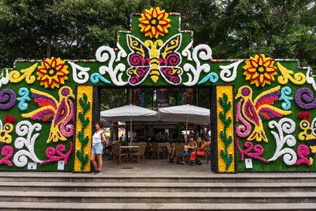 GARACHICO, TENERIFE - AUGUST 5, 2025: Colorful Fiesta de la Muerte festival arch decorated with paper flowers, butterfly and bird patterns at outdoor cafe entrance, Canary Islands.のeditorial素材