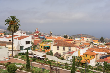 LA OROTAVA, TENERIFE, SPAIN - AUGUST 12, 2025: Panoramic view from Jardines Victoria over rooftops and church domes toward the coast.のeditorial素材