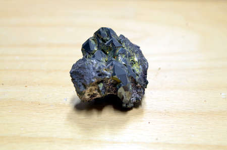 detailed macro photo of Hematite mineral (sacred mineral) isolated wooden background