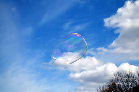 Soap rainbow bubble on blue sky backgroundの写真素材