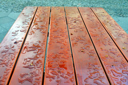 water drop on a wooden table outside after rainfallの写真素材