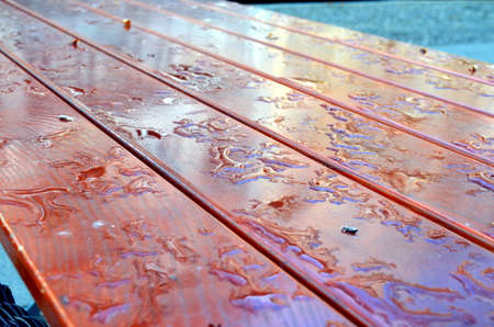 water drop on a wooden table outside after rainfallの写真素材