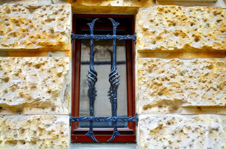 window with metal bars on street levelの写真素材
