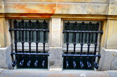 window with metal bars on street levelの写真素材