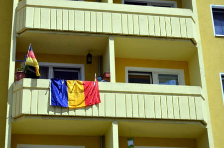 residential house decorated with german and romanian flagの写真素材